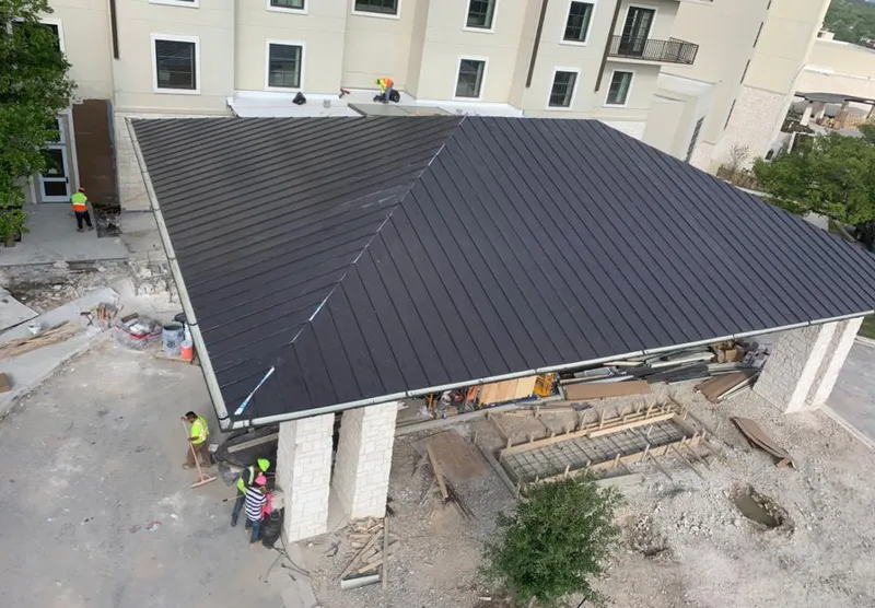 Metal roofing installation team working on a commercial building in Greene